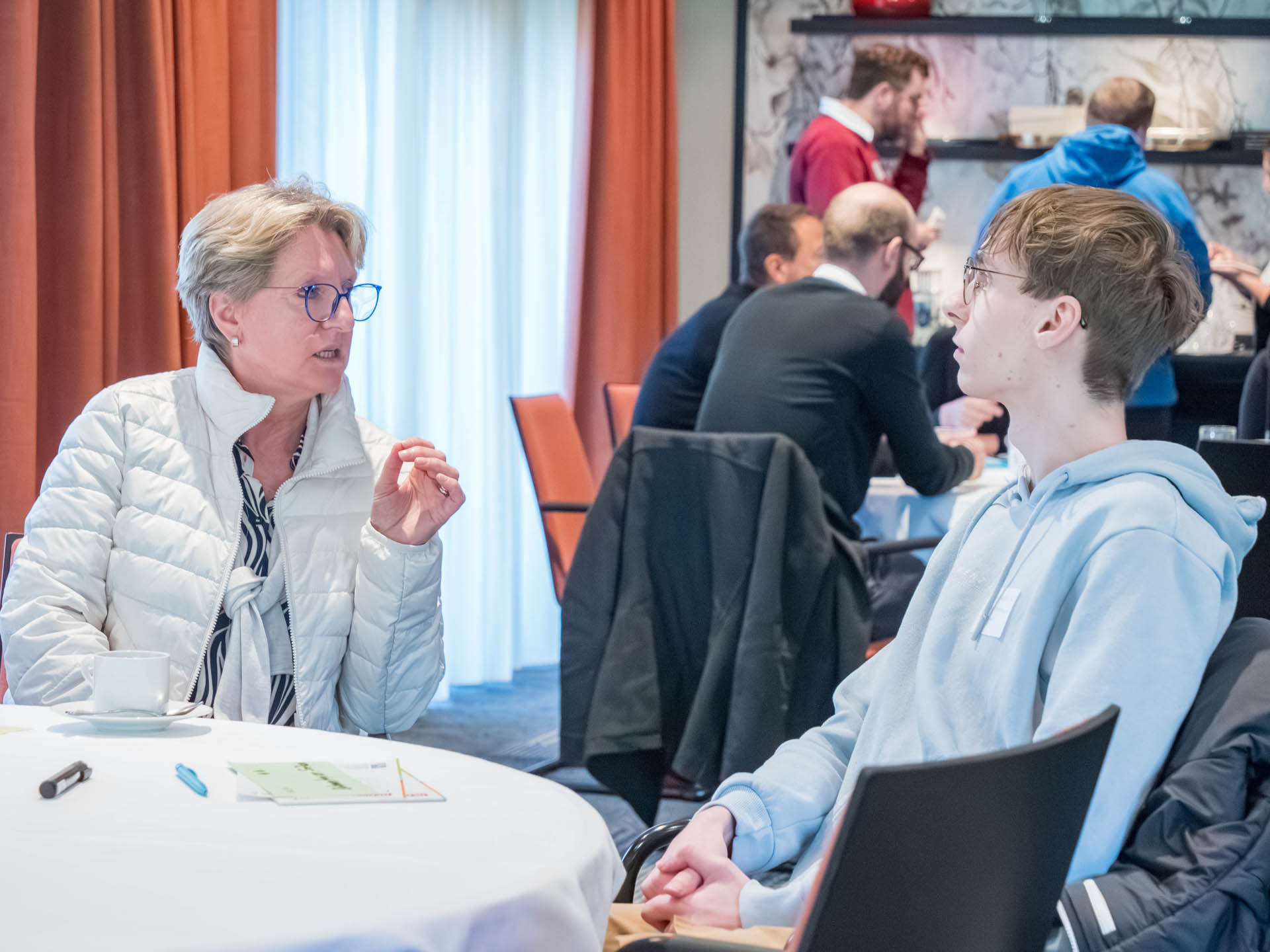 Eine Frau und ein Mann unterhalten sich an einem Tisch